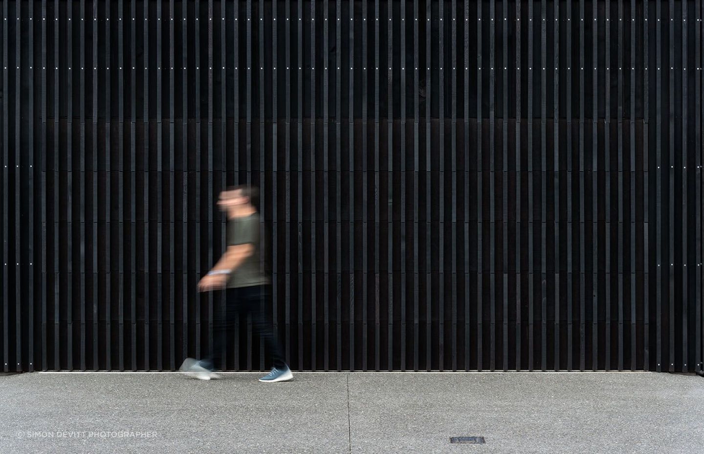 Black-stained vertical timber fins extend upwards, protecting the home from prying eyes.