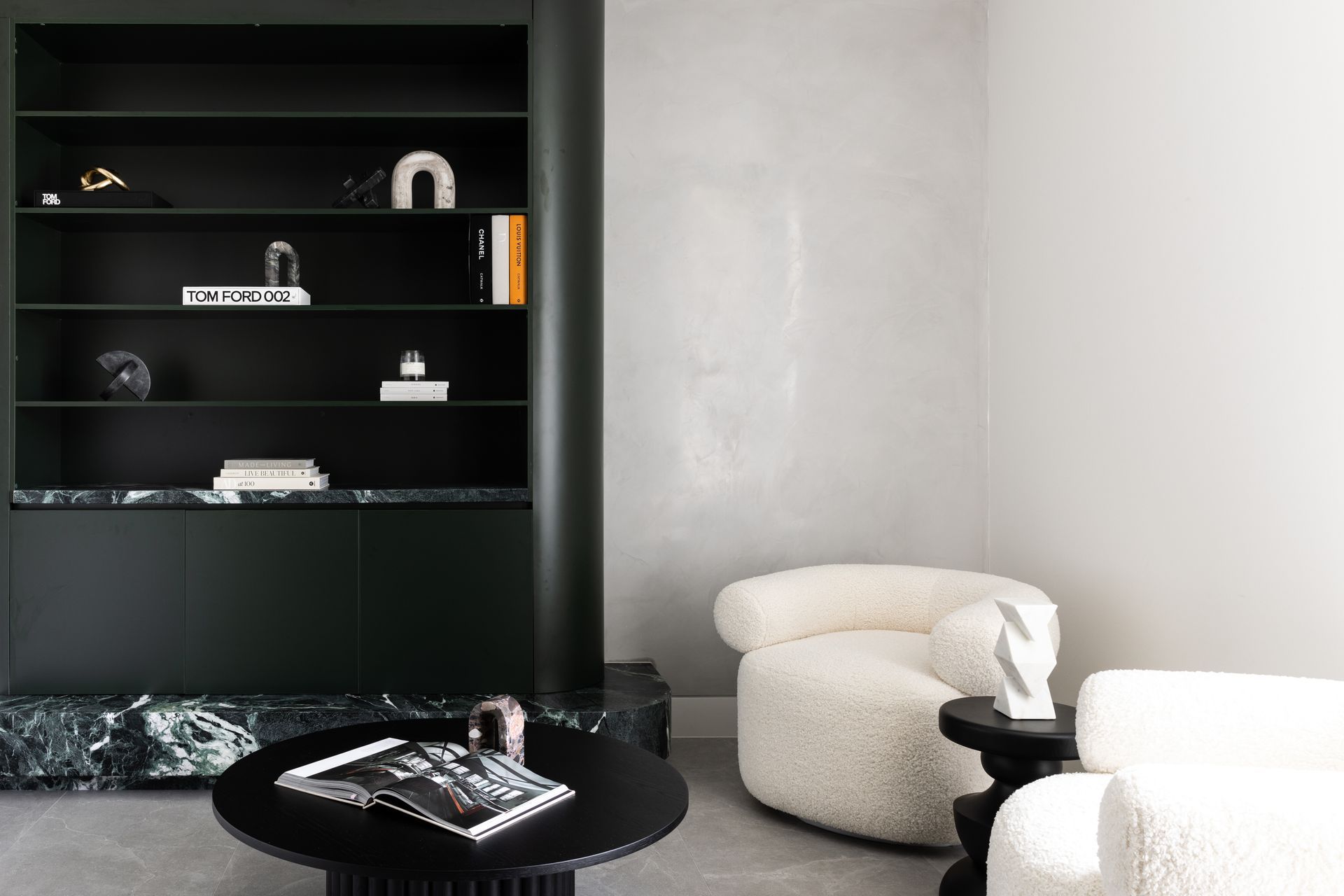 Dark green cabinetry and stone contrast with light Venetian plaster in the reading area.