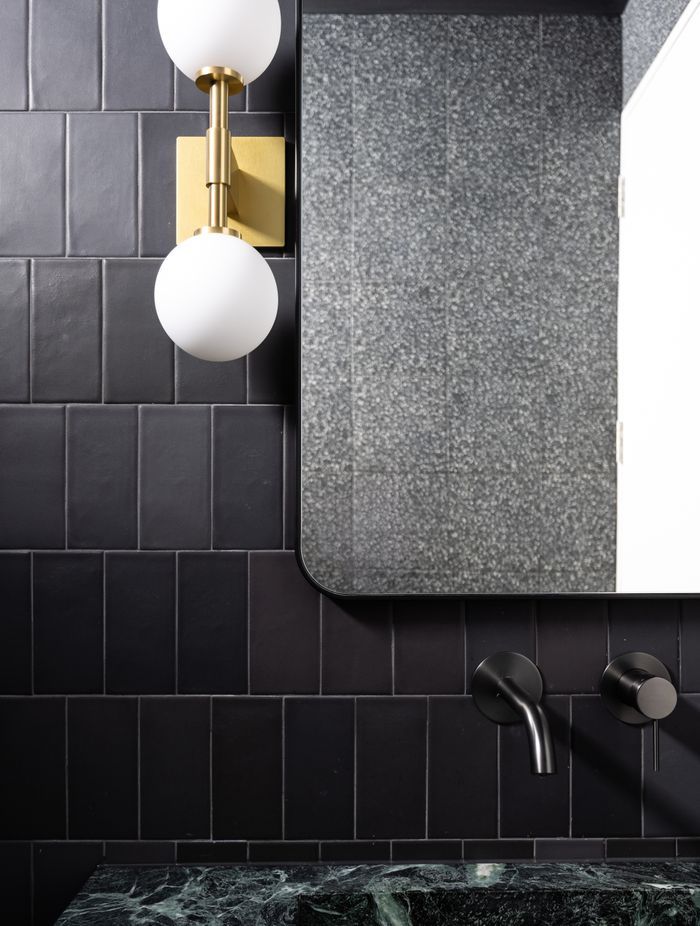 The brass wall light from Allied Maker is a luxurious touch to the bathroom.