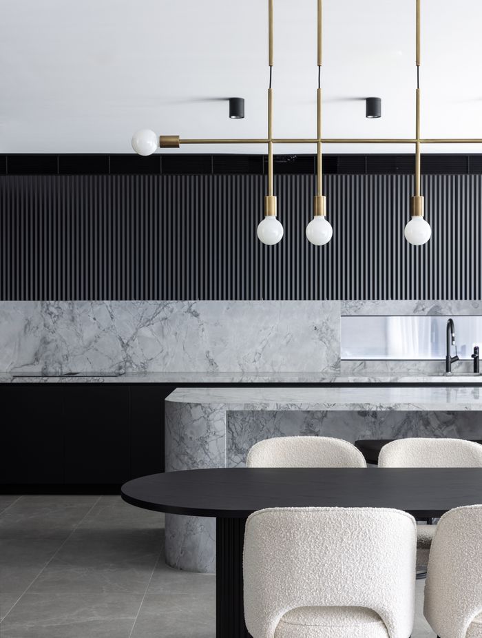 The brass pendant ties in with brass accents found throughout the home – even the feet of the dining chairs.