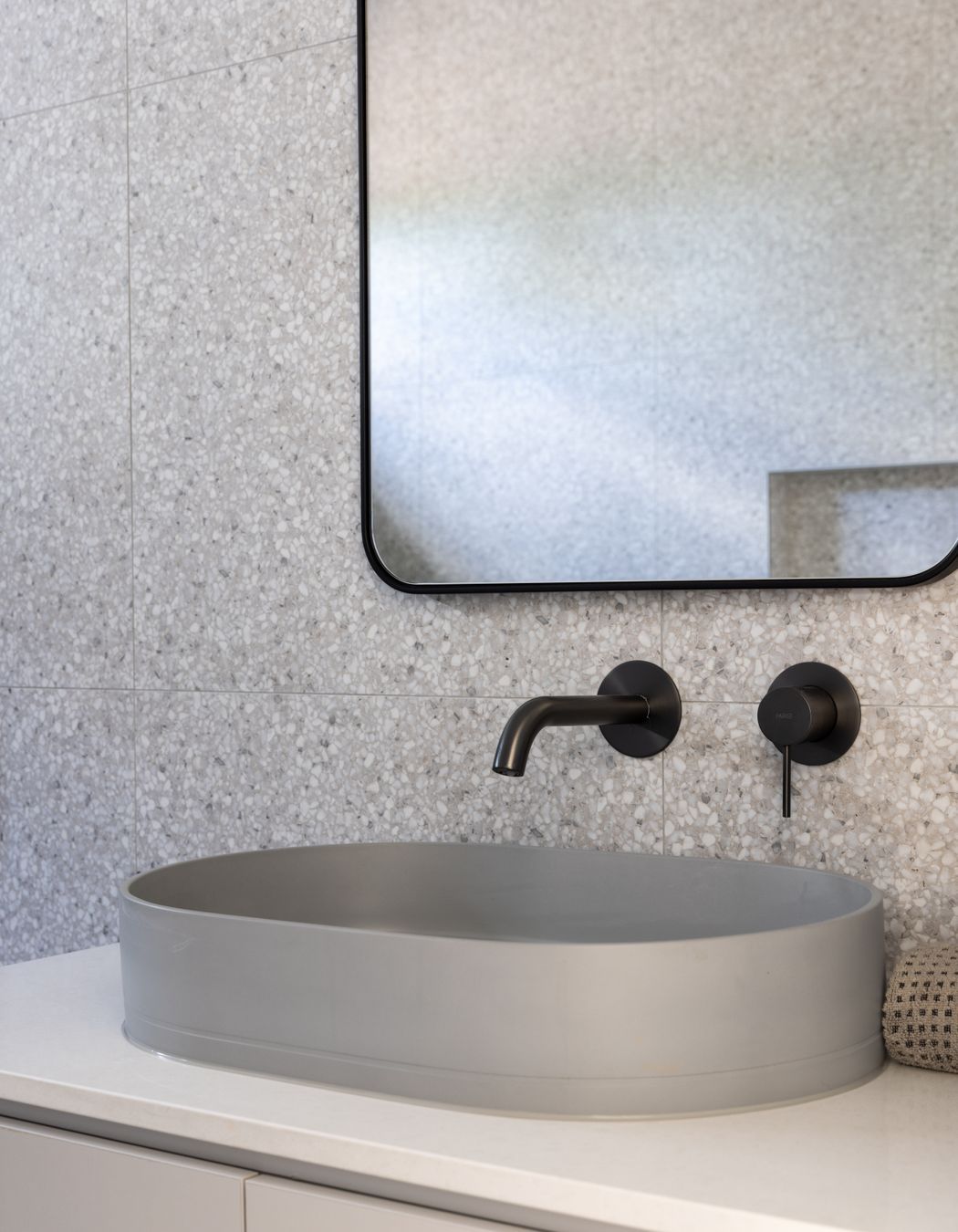 Terrazo, marble and concrete come together in the main bathroom.