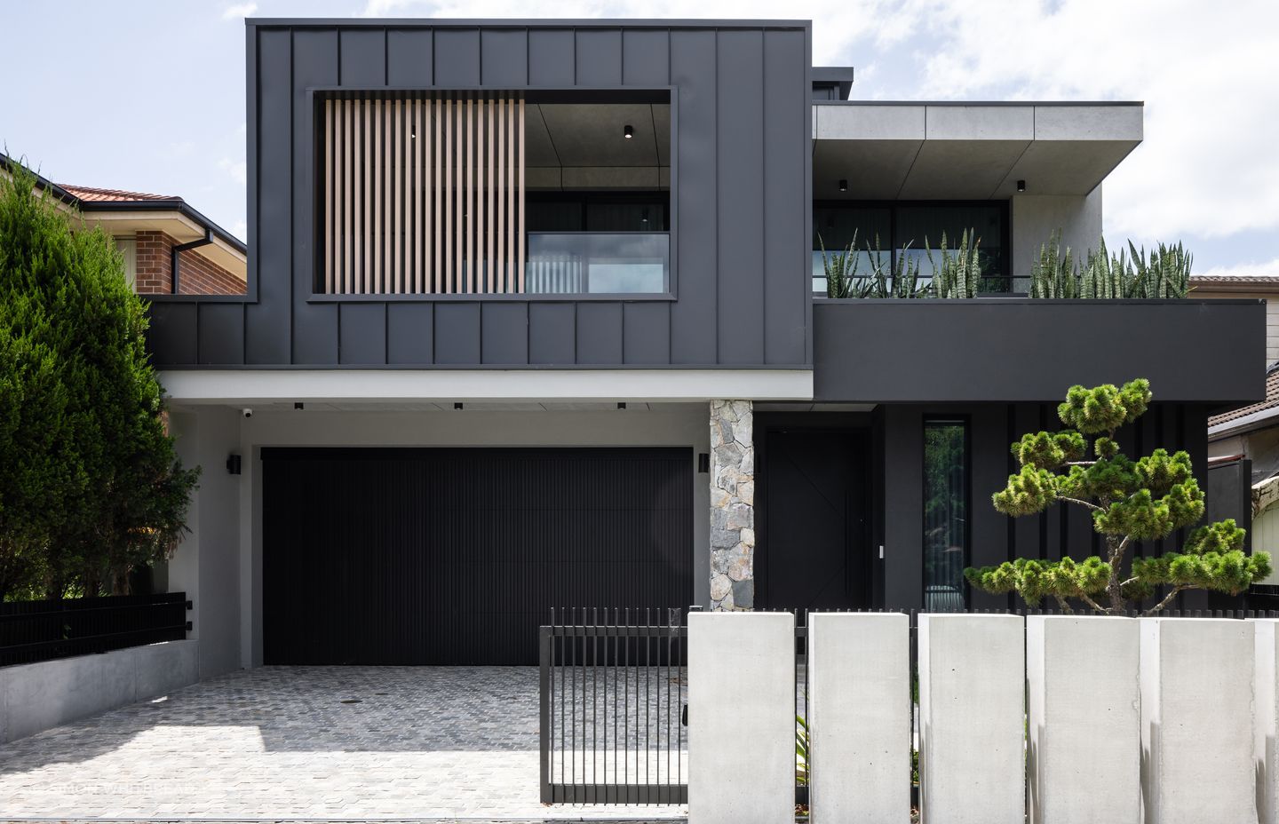 The exterior is a prelude to the interior: concrete, natural stones and dark surfaces.