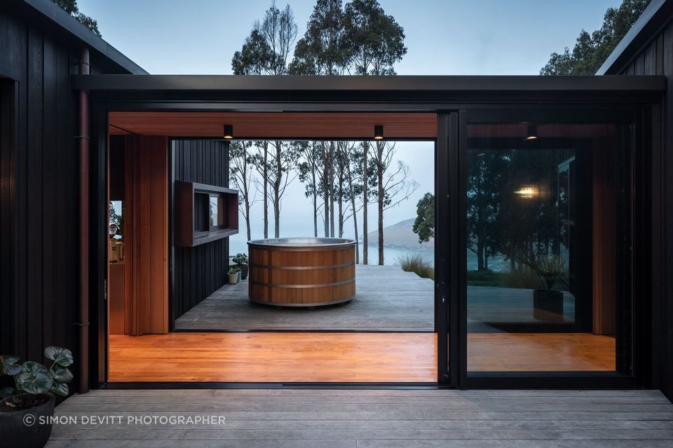 The link, while being a connecting space, acts as a mediator and wind break between two of the three outdoor decks, accessed on either side by sliding doors.