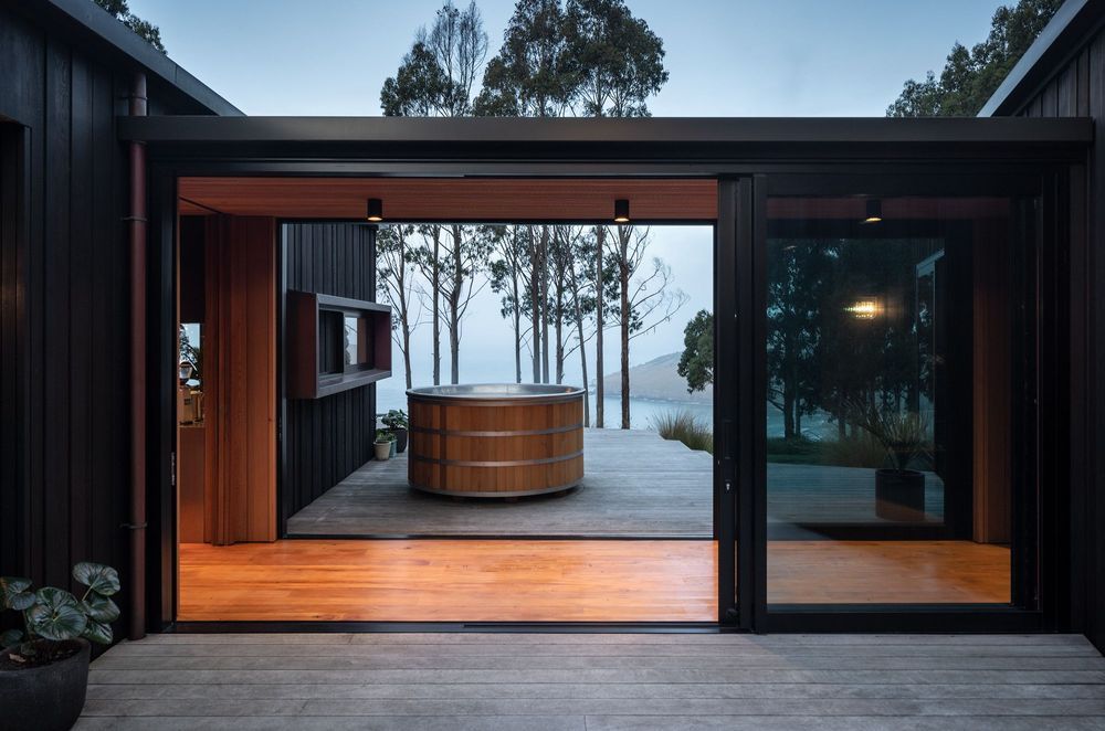 The link, while being a connecting space, acts as a mediator and wind break between two of the three outdoor decks, accessed on either side by sliding doors.