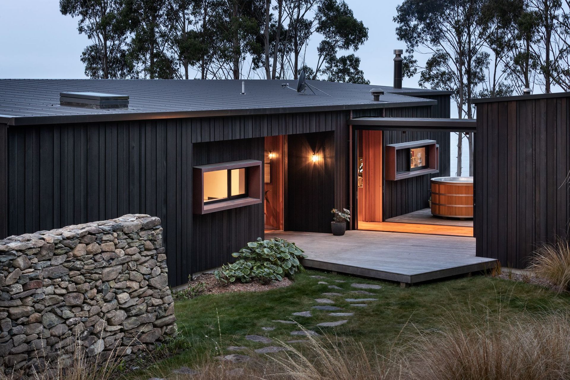 The house is formed into distinct timber building blocks that are joined by a glazed linkway.