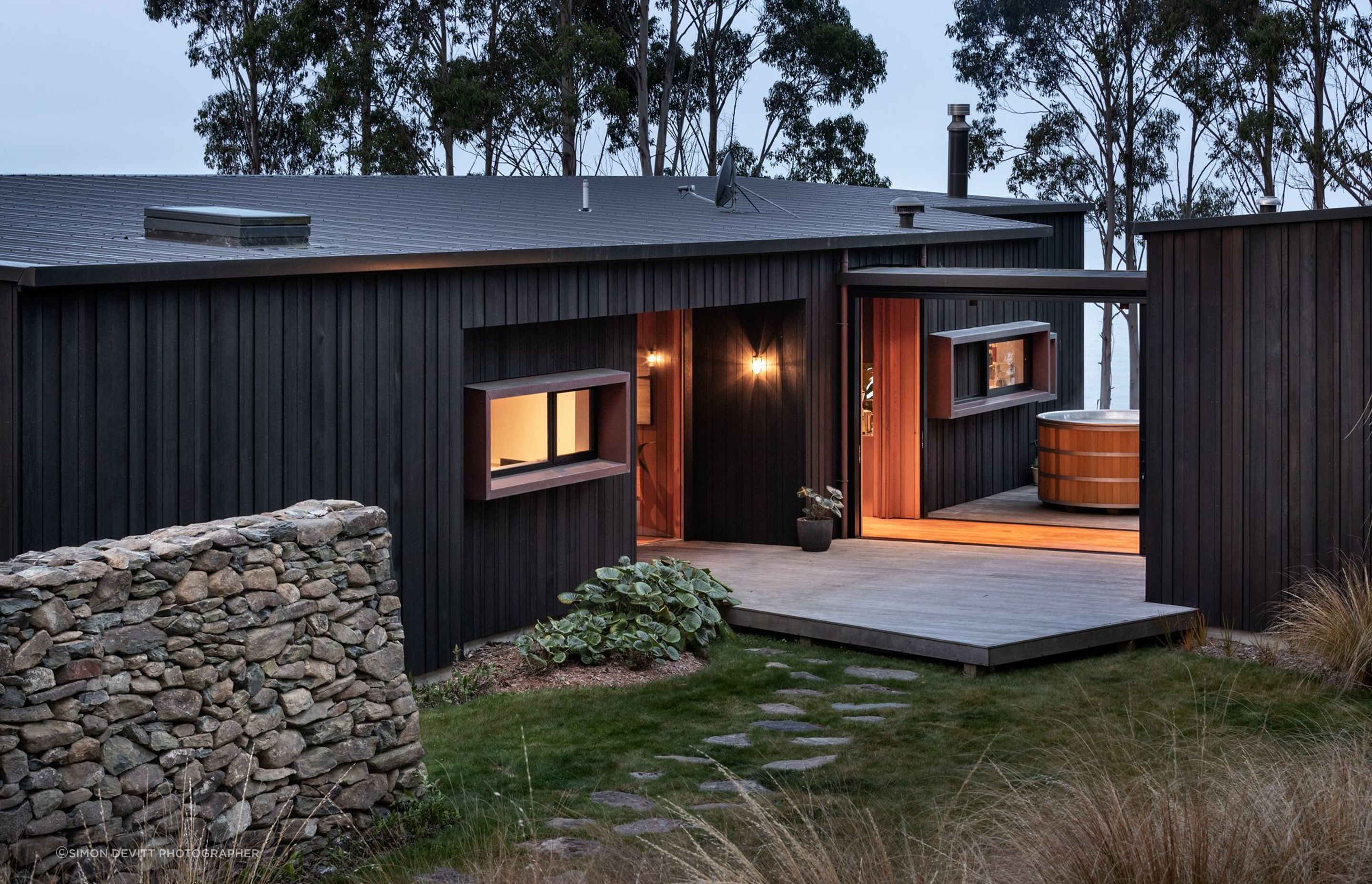The house is formed into distinct timber building blocks that are joined by a glazed linkway.