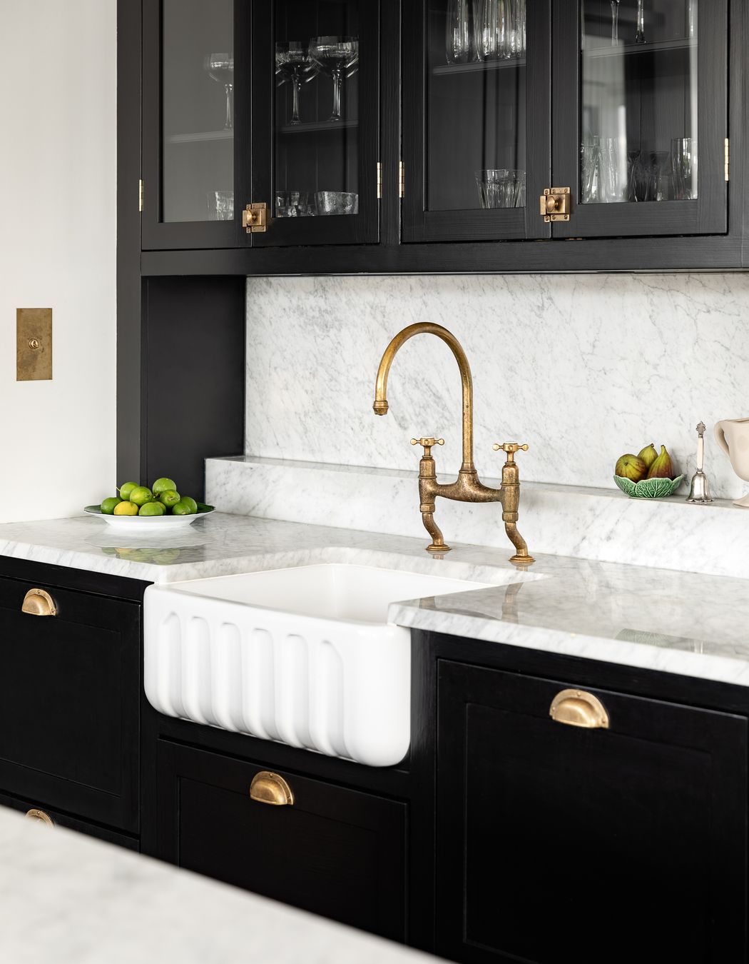 Brass hardware beautifully accents the black kitchen cabinetry.