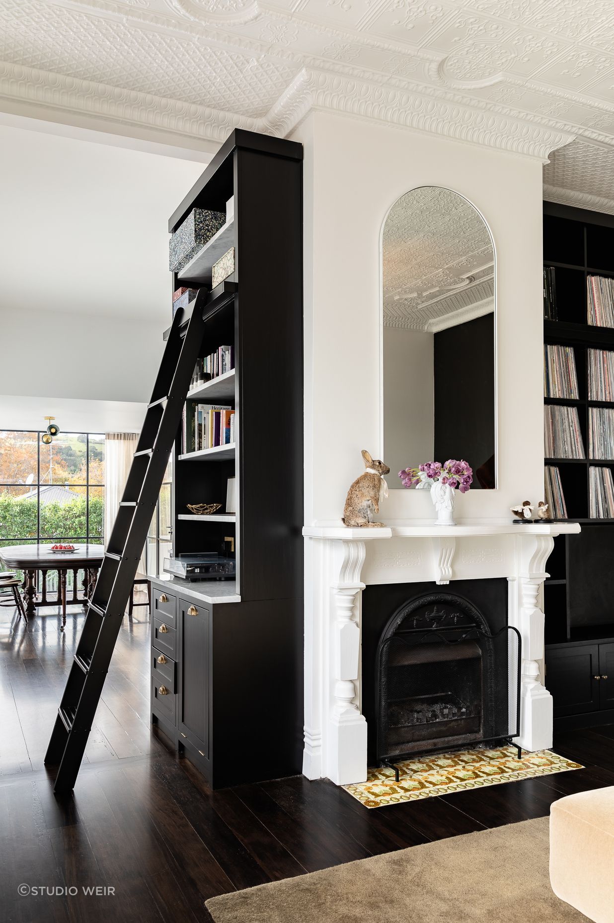 The bespoke timber library with ladder access holds a categorised 1,000+ strong vinyl collection that has been almost 20 years in the making. There is also a laundry chute hidden in cabinetry at the base of the bookshelf.