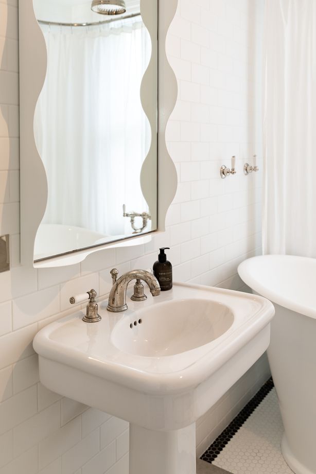 A wavy mirror brings a sense of fun to the children's bathroom. The traditional-style tapware is Perrin & Rowe.