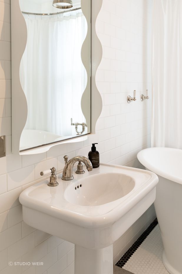 A wavy mirror brings a sense of fun to the children's bathroom. The traditional-style tapware is Perrin &amp; Rowe.