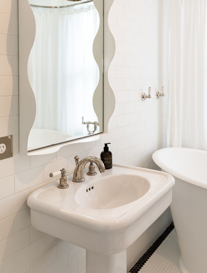 A wavy mirror brings a sense of fun to the children's bathroom. The traditional-style tapware is Perrin & Rowe.