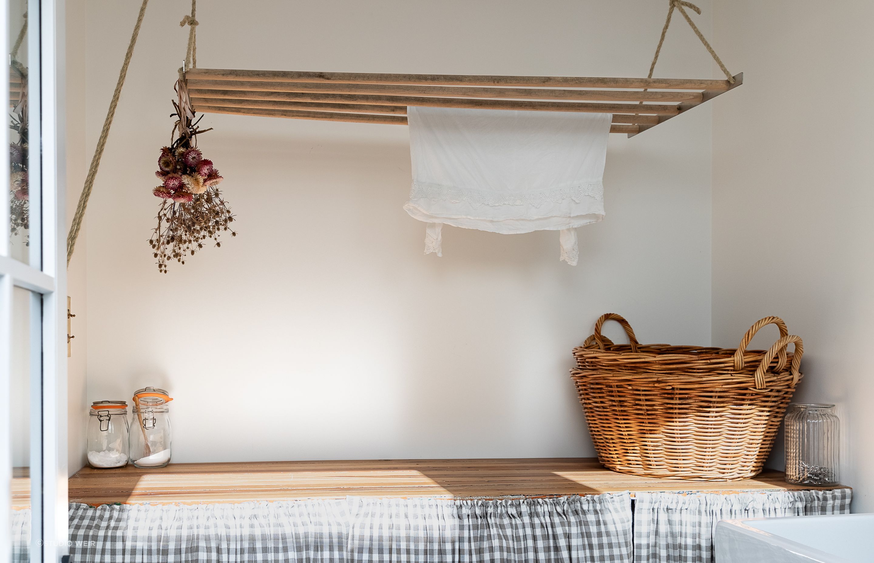 The laundry bench was made by German Kitchens out of old doors found under the house. The laundry skirt is by Island Interiors.