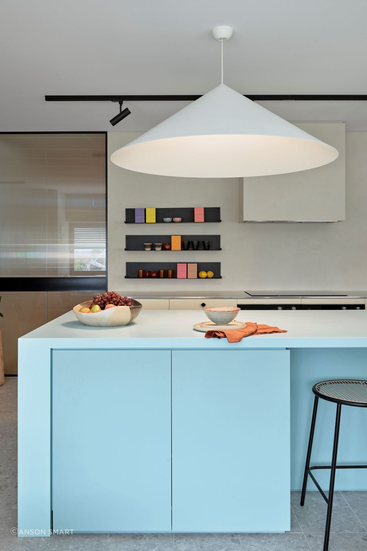 The kitchen combines strong shapes with soft, pastel colours to create a homely yet robust space for the staff to cook and eat.
