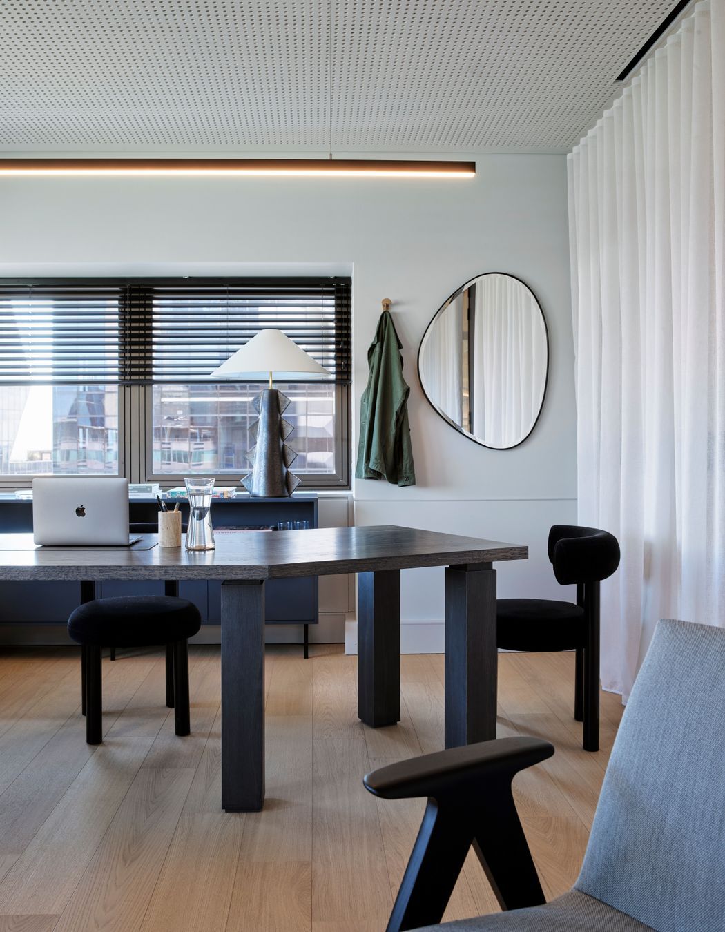 The warm timber floors of the office space juxtapose beautifully against the dark, sculptural furniture.