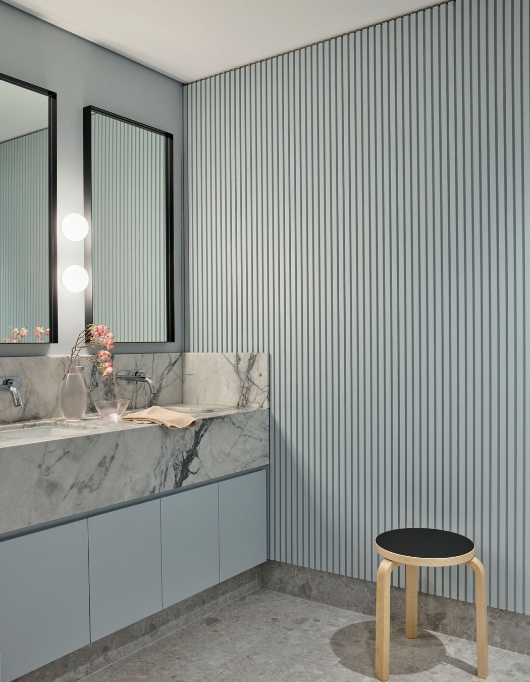 The soft ribbing in the wall panelling contrasts against the marble vanity in the bathroom.