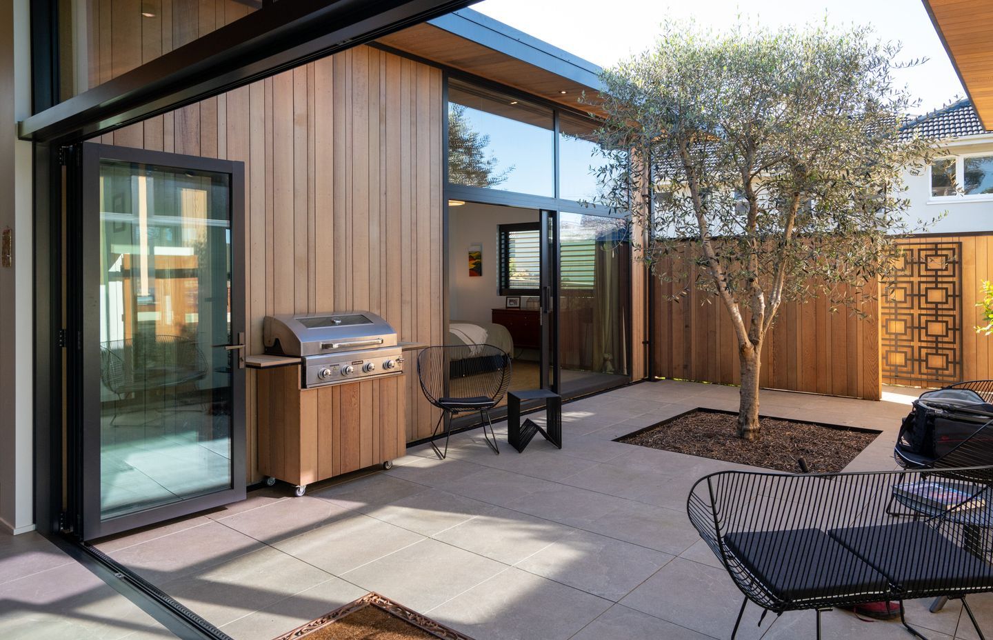 An established tree brings greenery to the courtyard space.