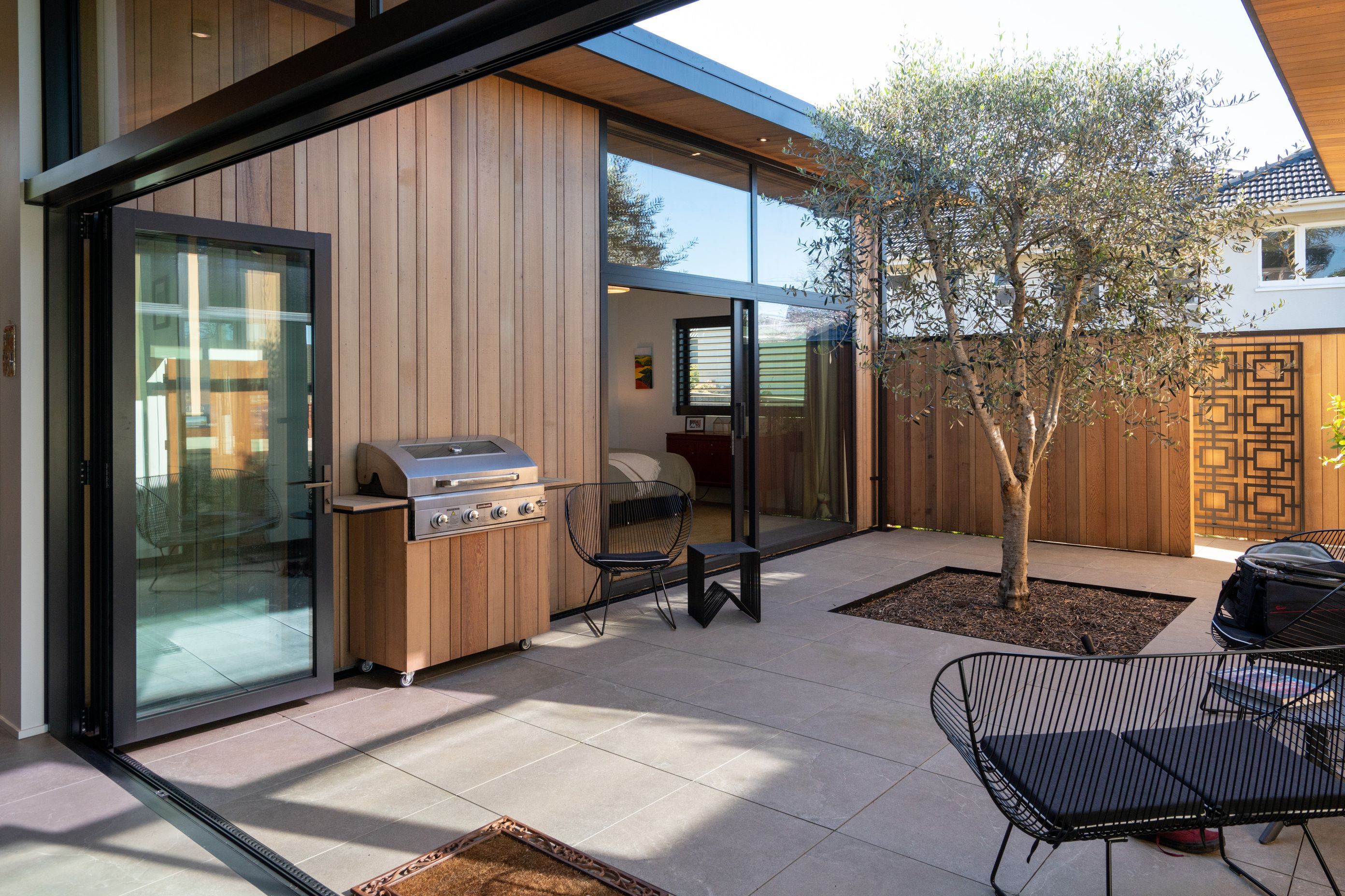 An established tree brings greenery to the courtyard space.