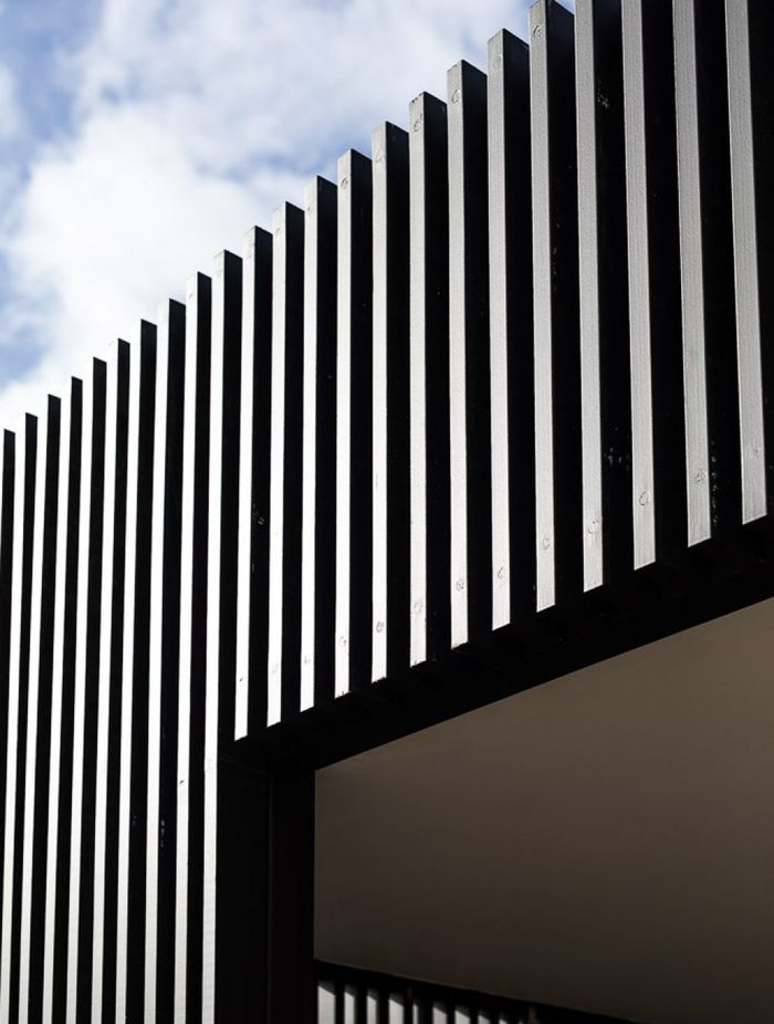 The vertical timber slats and boards contrast with the warmth of the stone.