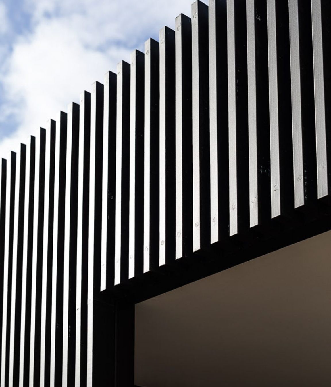 The vertical timber slats and boards contrast with the warmth of the stone.