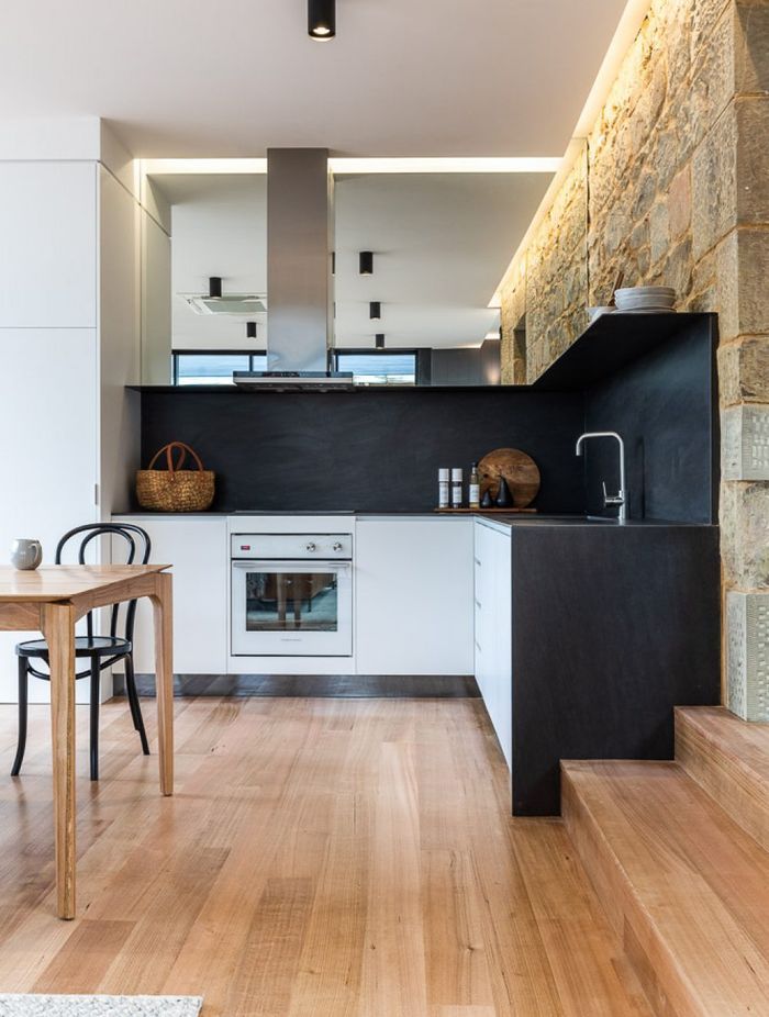 Light washes down the restored sandstone wall to accentuate its texture, complemented by a muted charcoal palette.