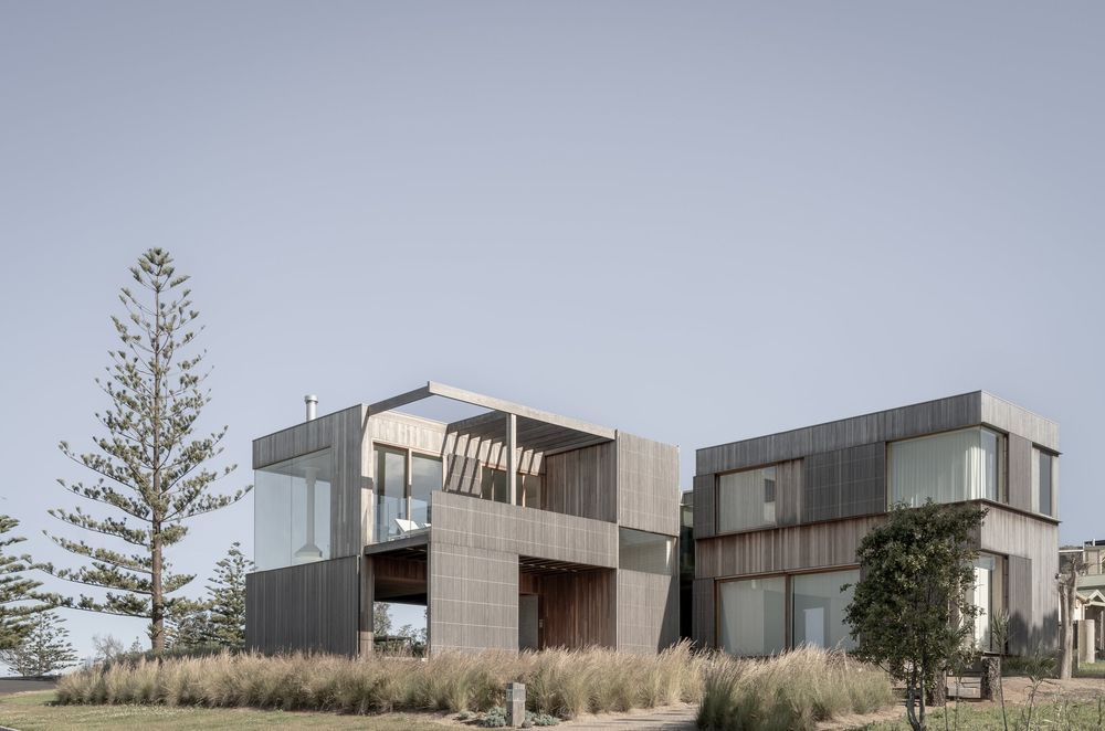 The striking weathered timber cladding and dune-like landscaping reflect the Bergamui Beach House's rugged setting.