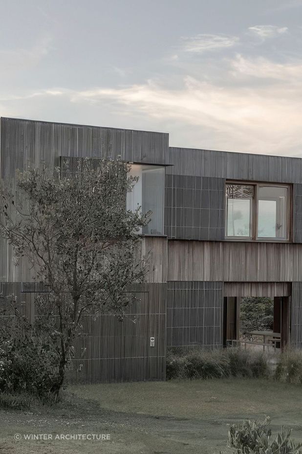 The weatherboard cladding blends with the surrounding grasslands.