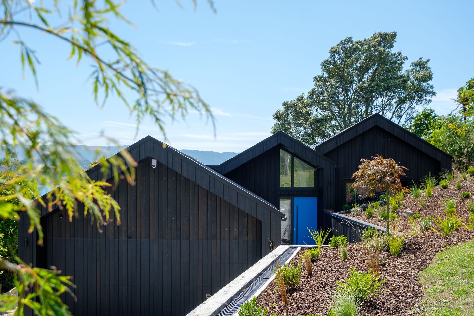 The exterior of Black Gables House, designed to passive house principles, with the tranquil Lake Tarawera in the distance.