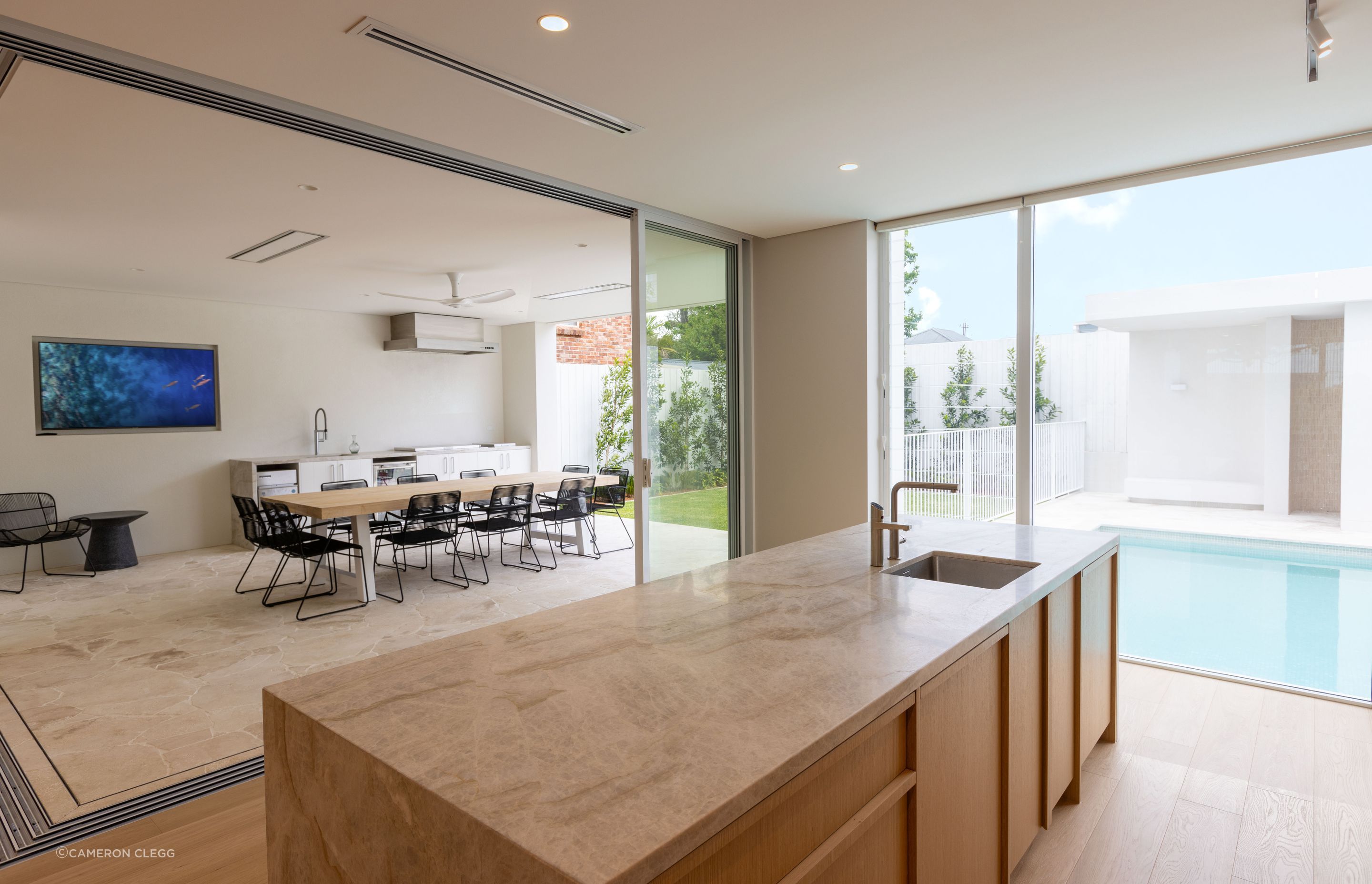 Floor-to-ceiling glazing seamlessly connects the indoor and outdoor spaces.