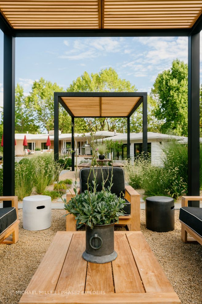 McCarthy's answer to the swiftly-changing summer heat was twin pergolas, one for dining, one for lounging, deliberately built to change function as the day cools, with a fire pit picking up the evening once the sun drops.