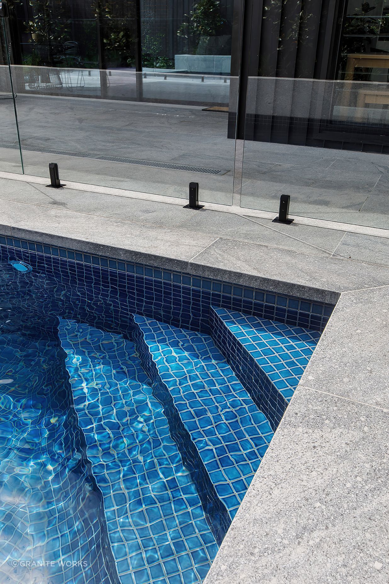 The flamed finish on the granite poolside paving provides slip resistance.
