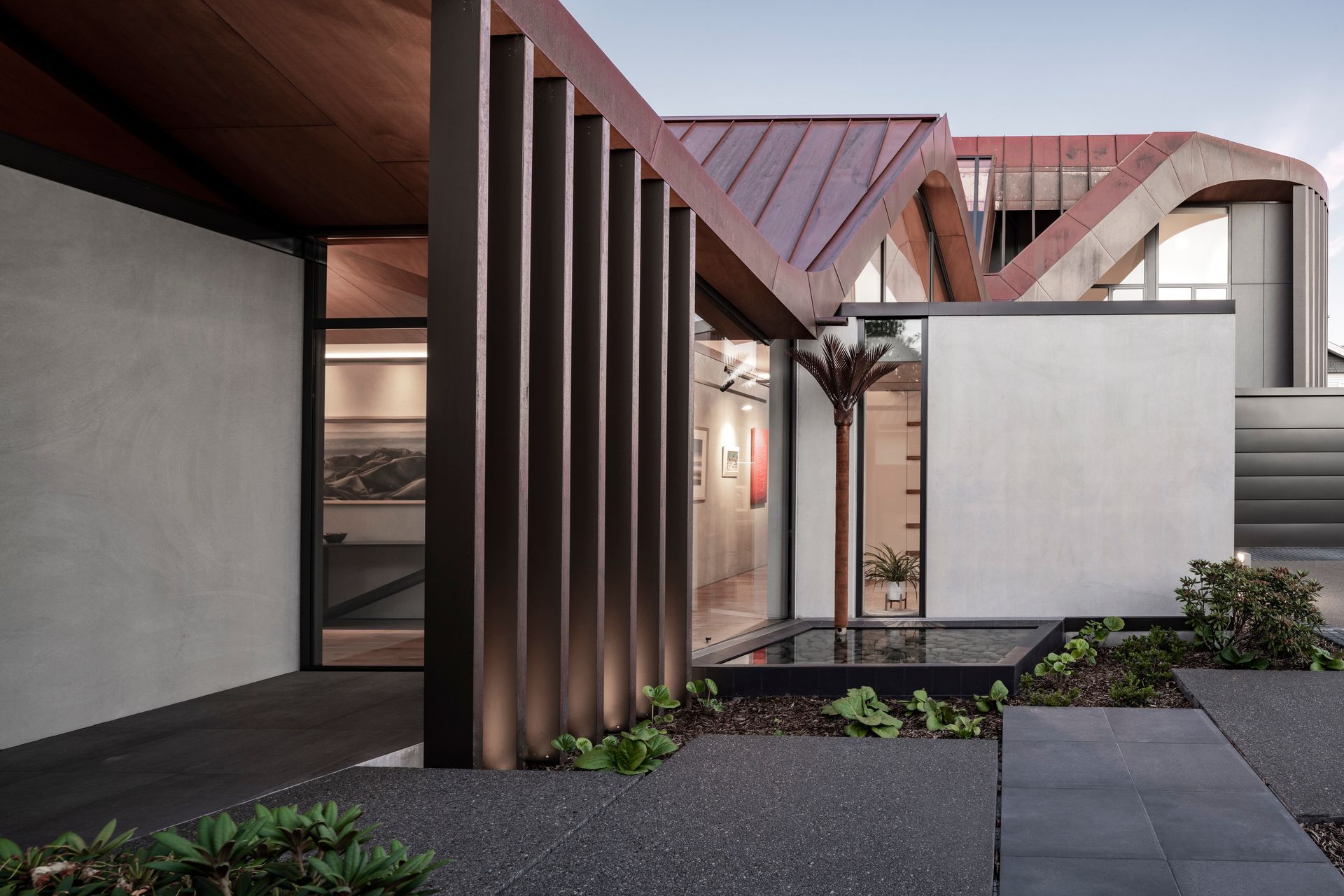 Very clever downpipes in the form of nīkau sculptures by Jane Downes preserve the shape of the roof.