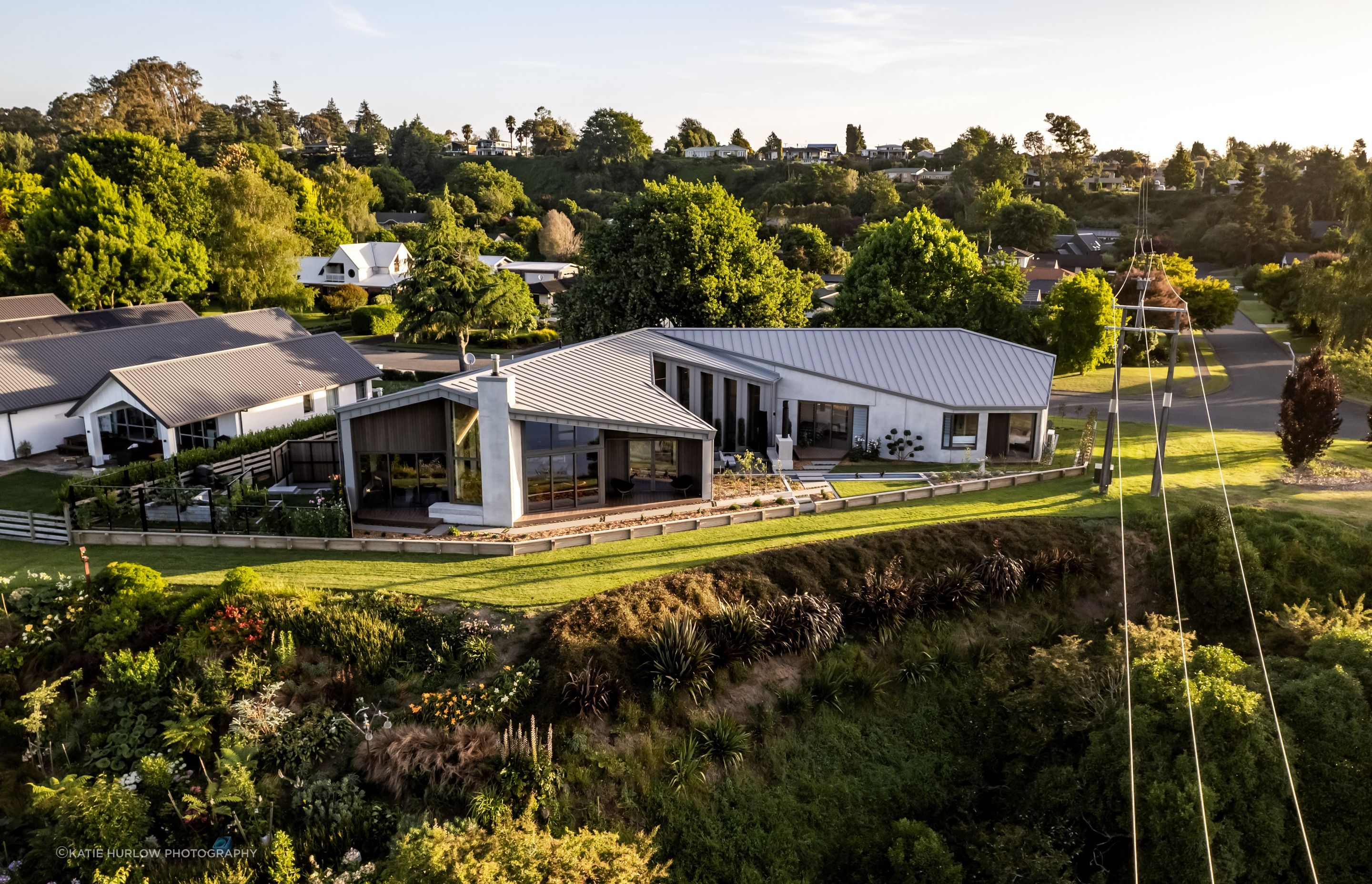 Seen from above, the sculptural form of the home hugs the landscape, drawing in the light and the views, while creating privacy from the street and neighbours.