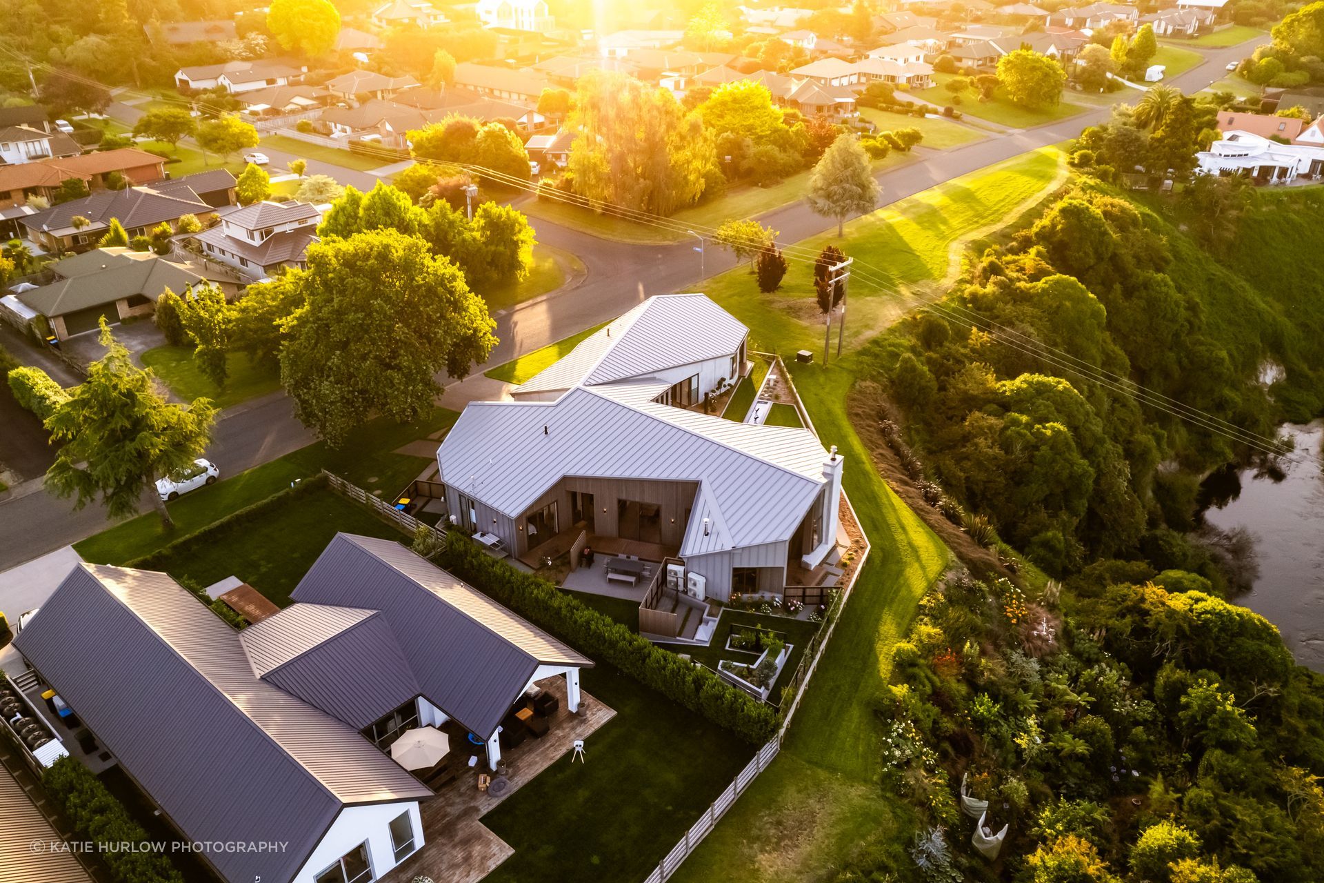 The complex roofline is a key feature of the home; the Waikato River meanders below.