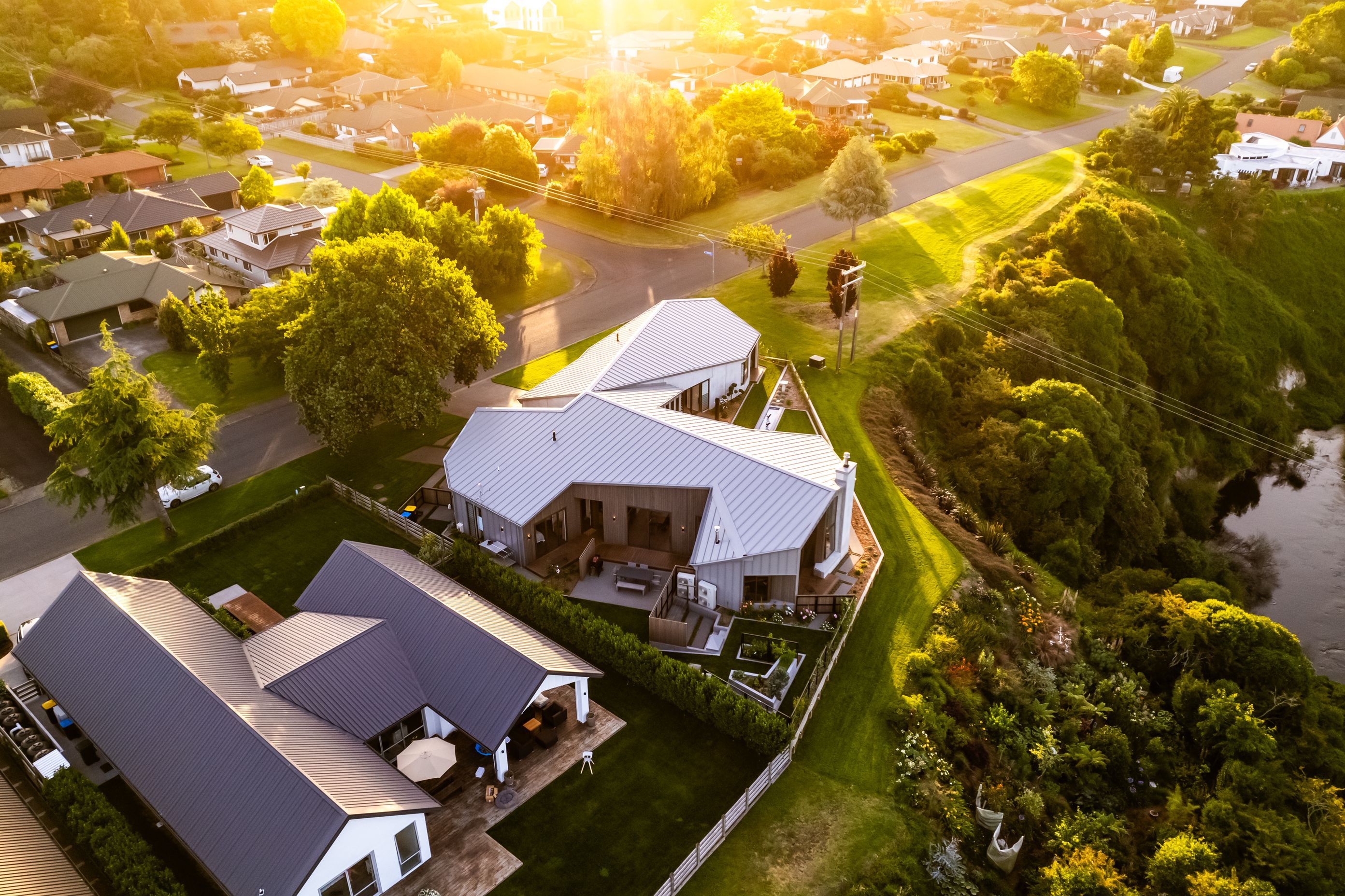 The complex roofline is a key feature of the home; the Waikato River meanders below.