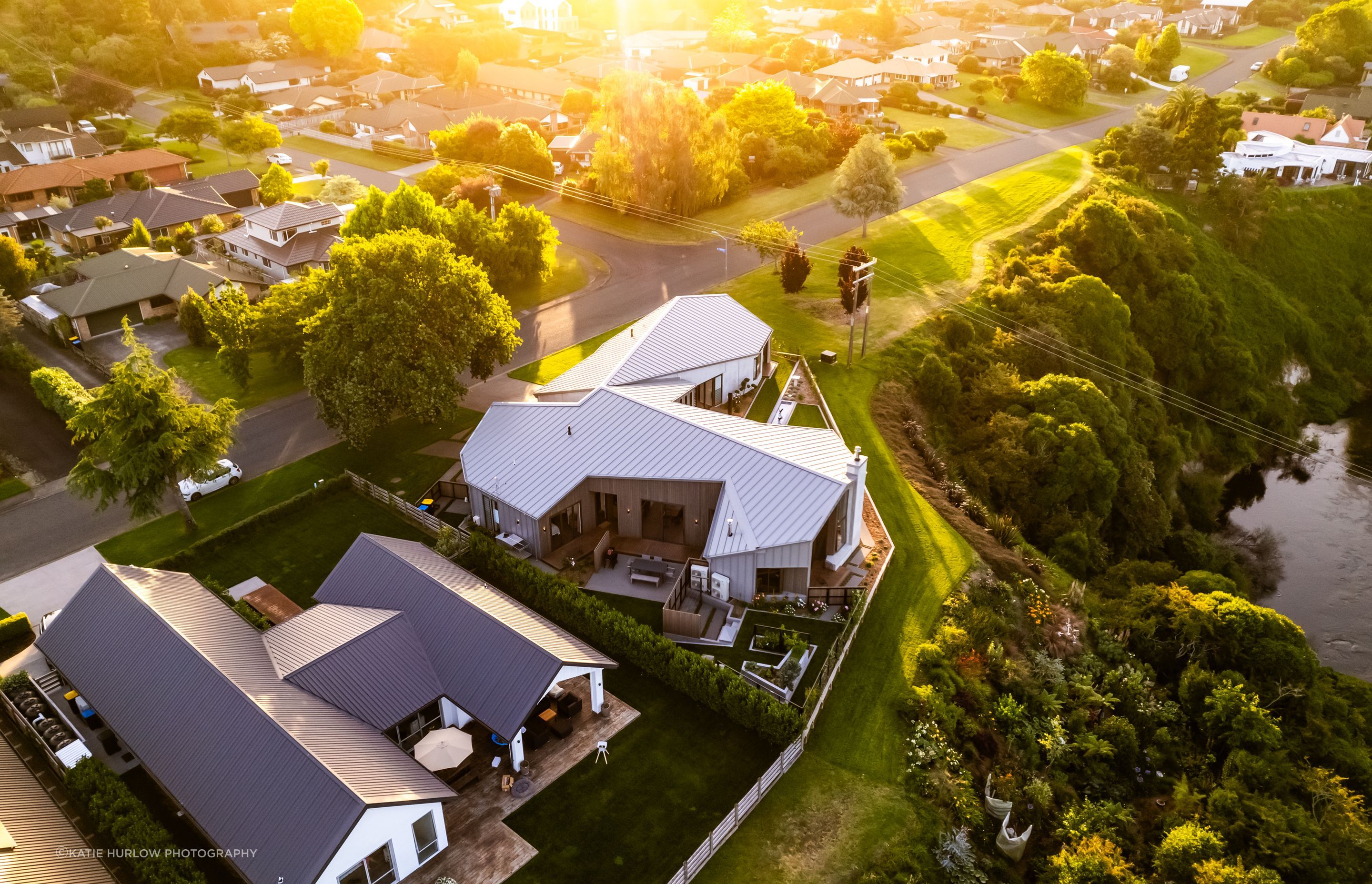 The complex roofline is a key feature of the home; the Waikato River meanders below.