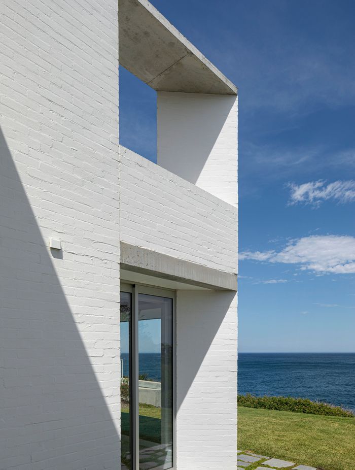The bagged brick walls on either side of the house create two protective spines for the home.