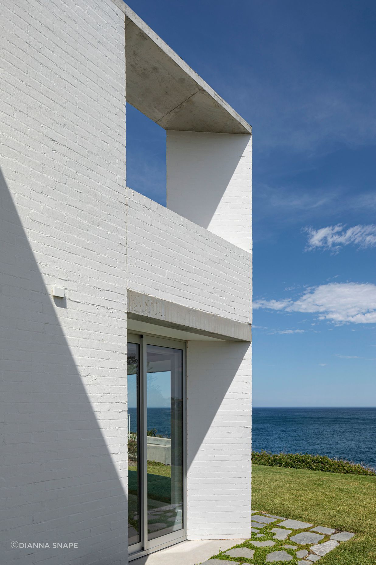 The bagged brick walls on either side of the house create two protective spines for the home.