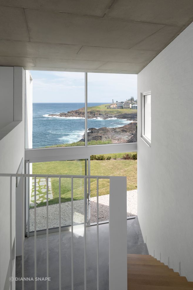 The double-height void allows light into the central living spaces from the street front side of the home.