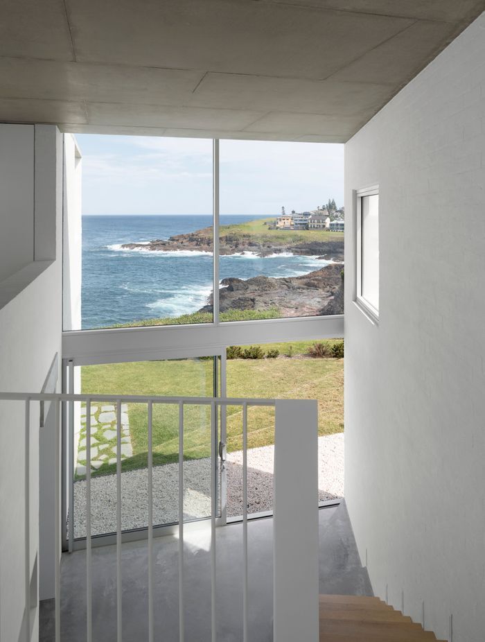 The double-height void allows light into the central living spaces from the street front side of the home.