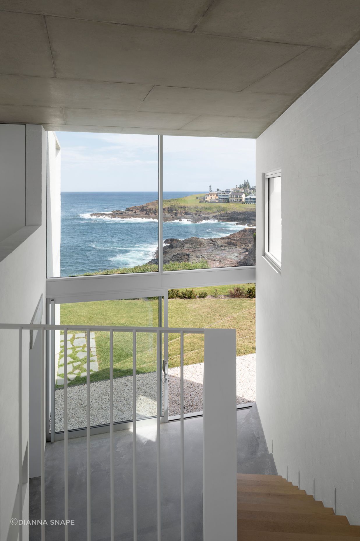 The double-height void allows light into the central living spaces from the street front side of the home.