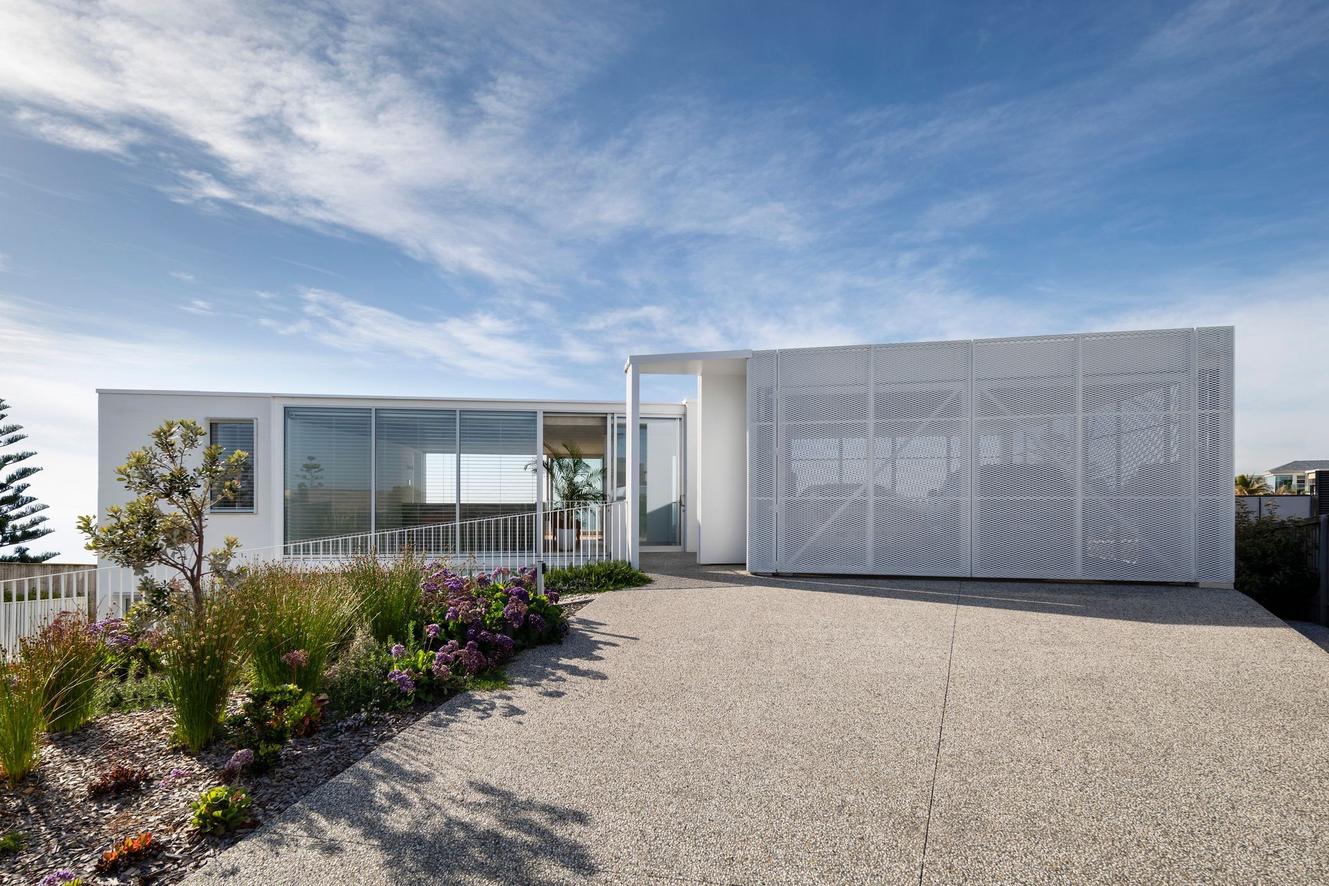 Perforated garage doors at the upper level soften the home's strong, geometric form.