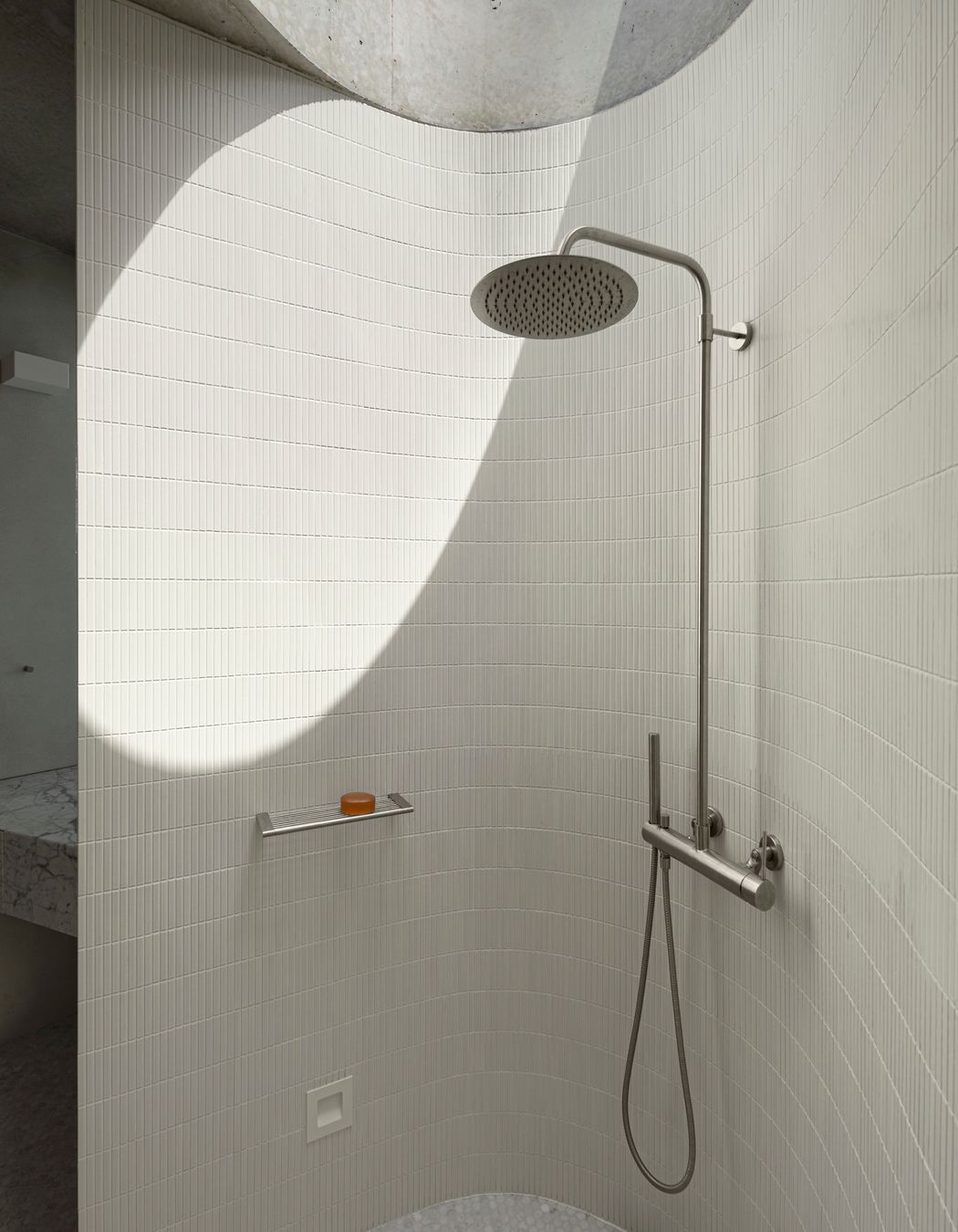 The curves of the shower room are echoed in the circular skylight.