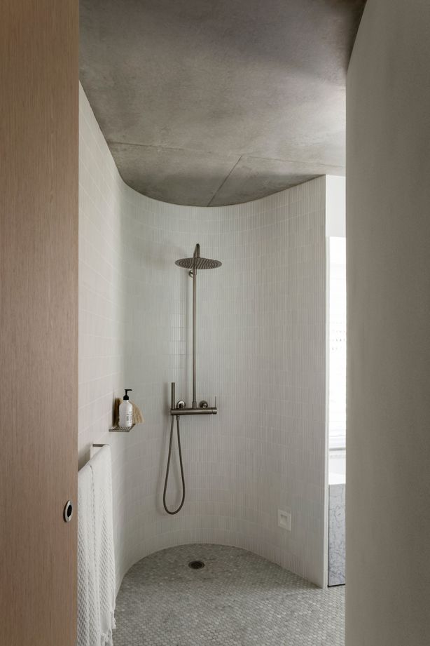 A curved shower room looks as if hewn out of stone.