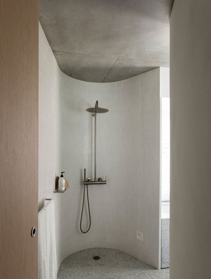 A curved shower room looks as if hewn out of stone.
