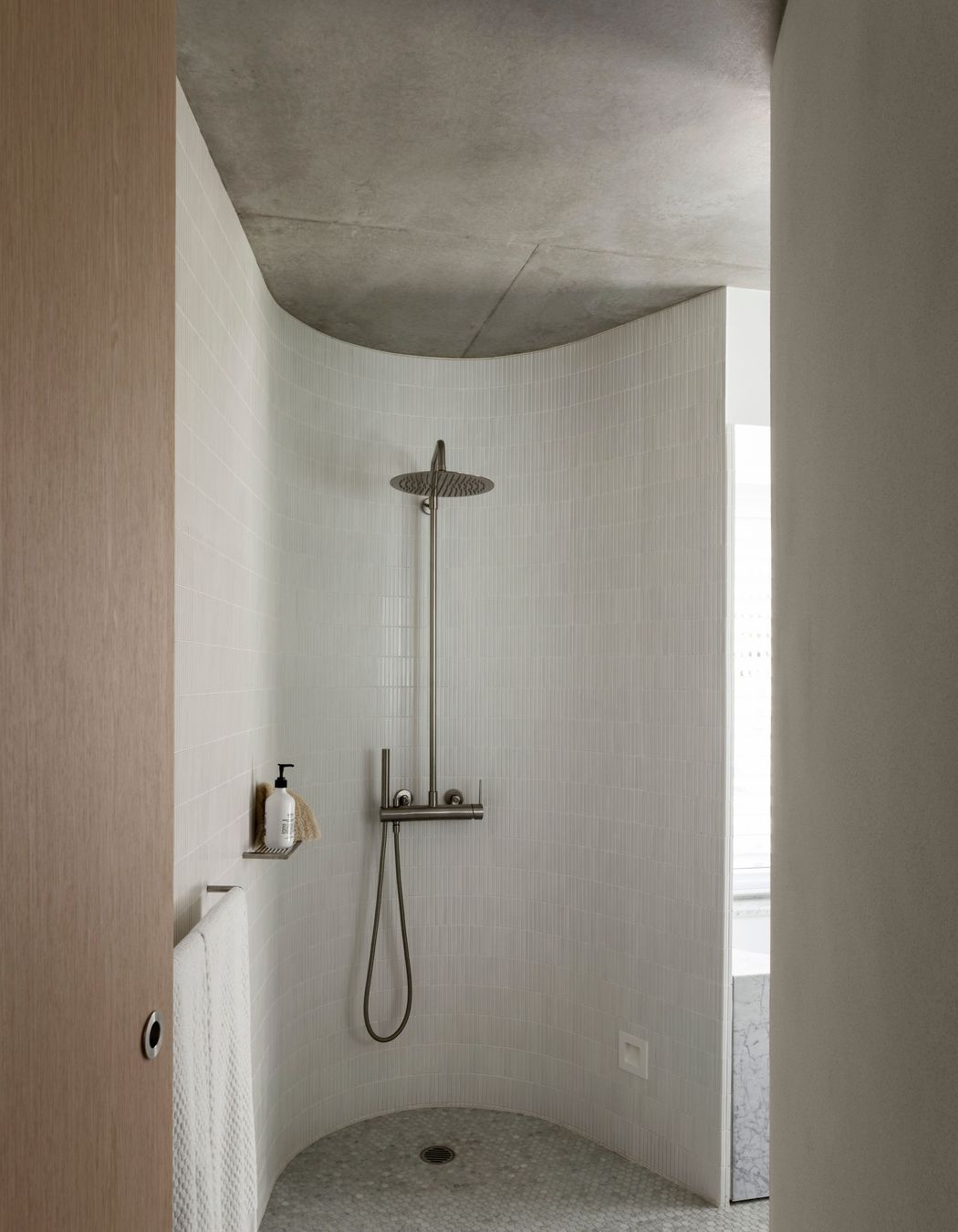 A curved shower room looks as if hewn out of stone.