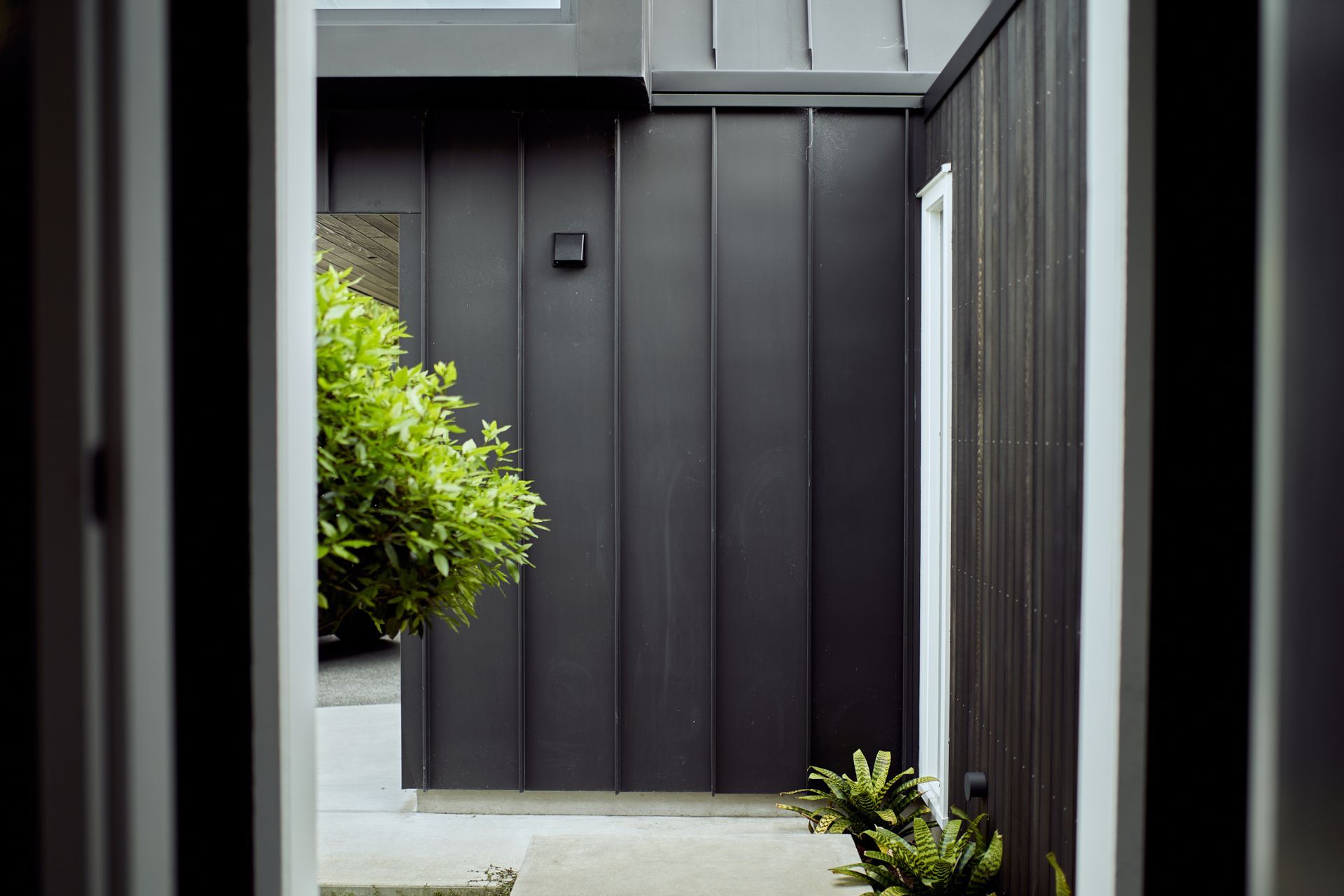 Steel tray cladding interconnects easily with stained cedar and weatherboard.