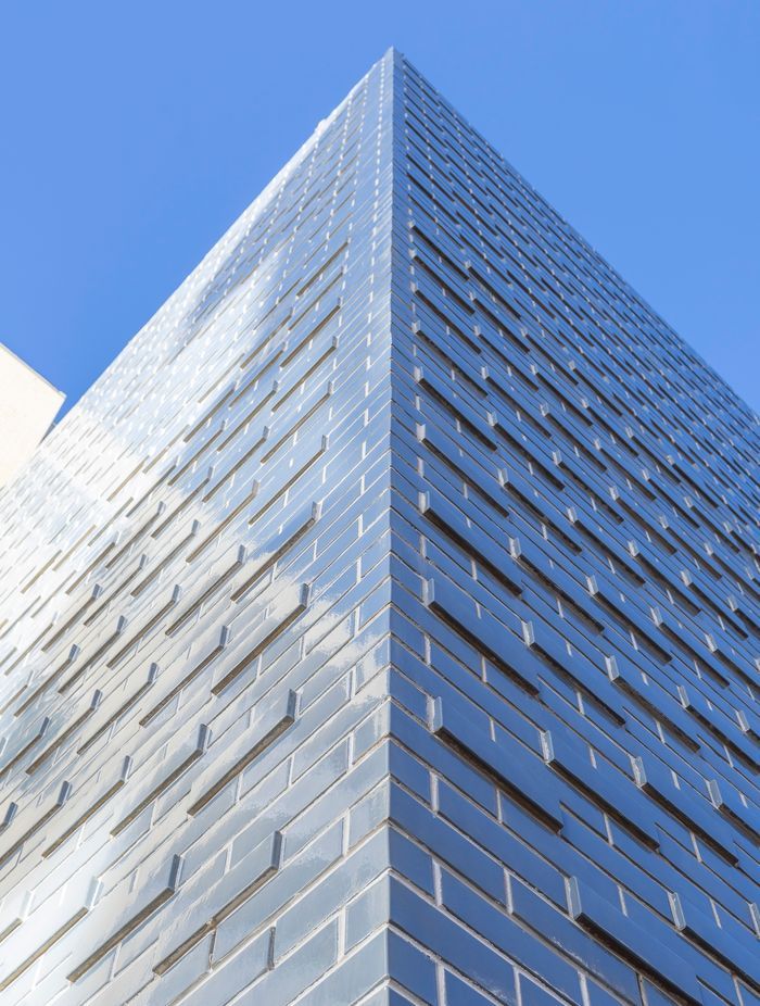 The glazed brick façade shimmers in the sunlight.
