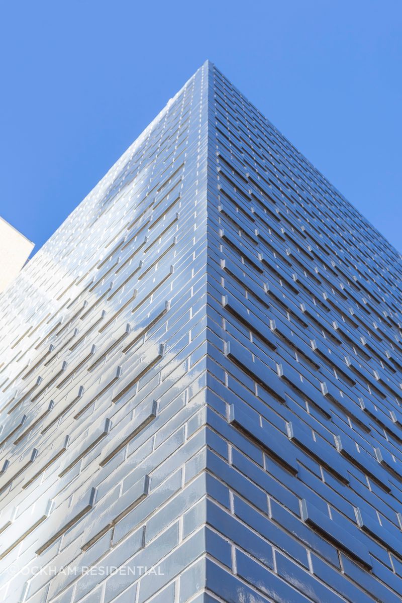 The glazed brick façade shimmers in the sunlight.