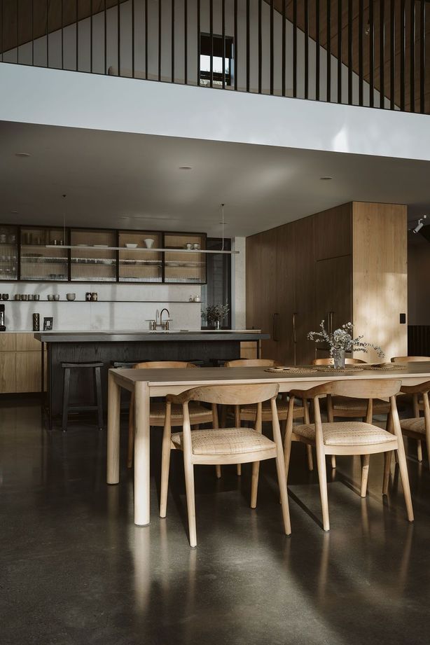The kitchen was designed, manufactured and installed by Glen John Kitchens and features hardwood cabinetry with fluted glass, a dark stained island bench and an open-plan design that connects with the dining area.