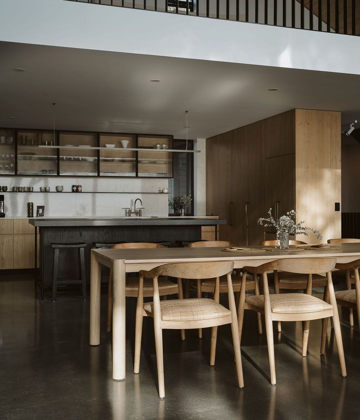 The kitchen was designed, manufactured and installed by Glen John Kitchens and features hardwood cabinetry with fluted glass, a dark stained island bench and an open-plan design that connects with the dining area.